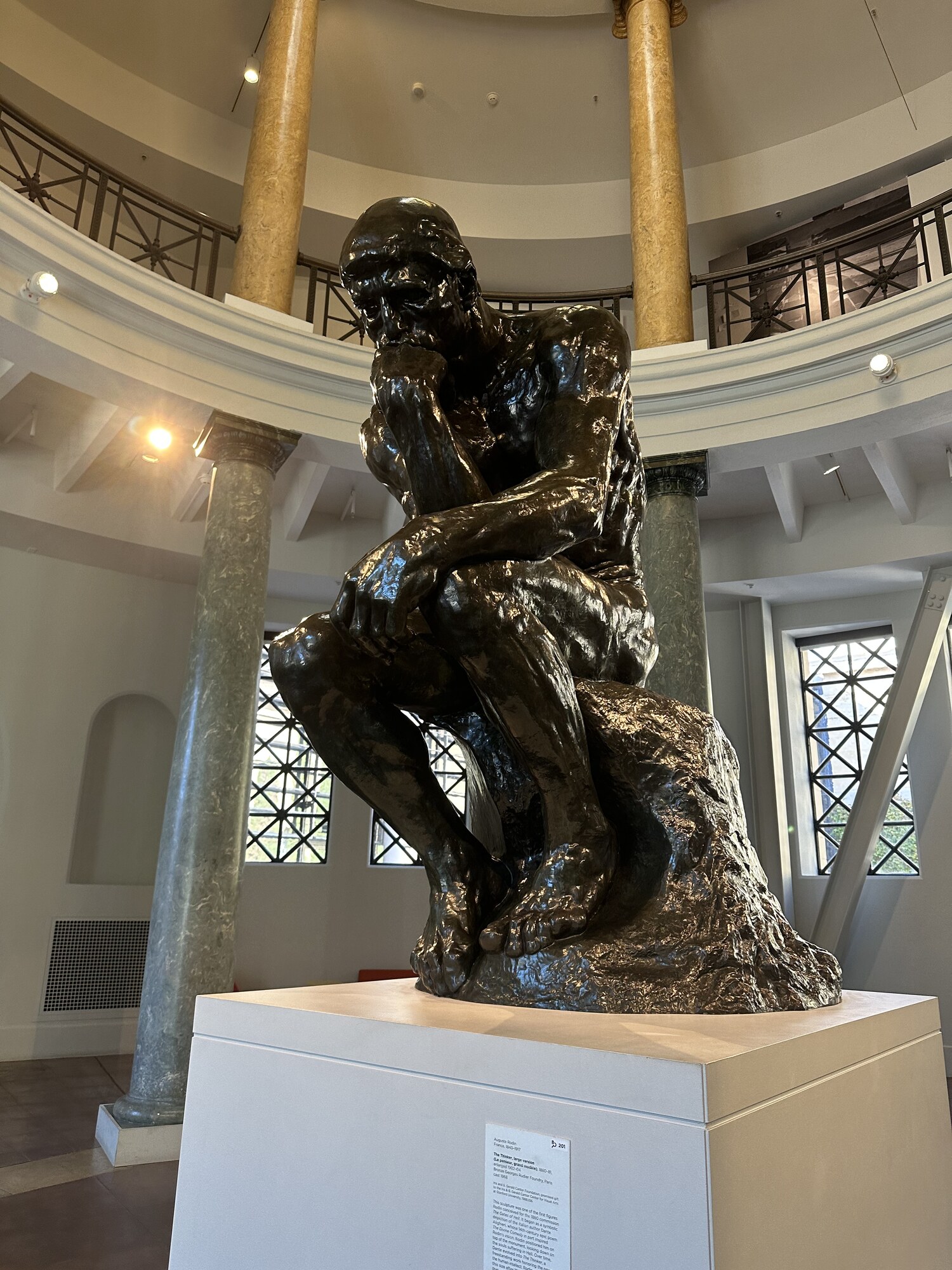 A bronze figure seated with the body drawn inward.