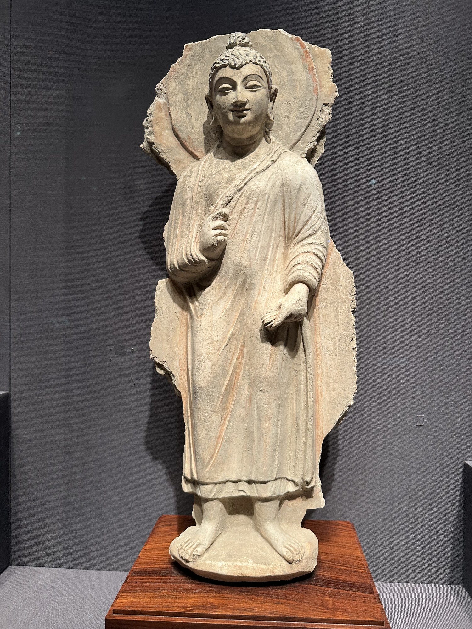 A standing stone figure with a raised hand.