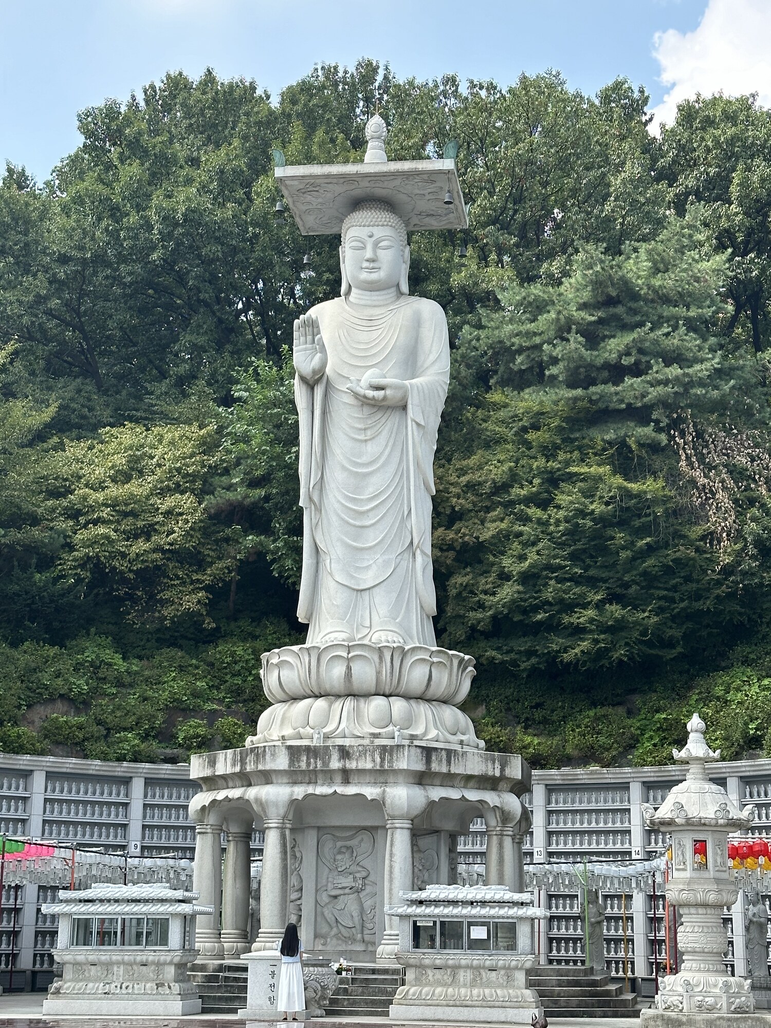 Visitors at the foot of a tall white statue.