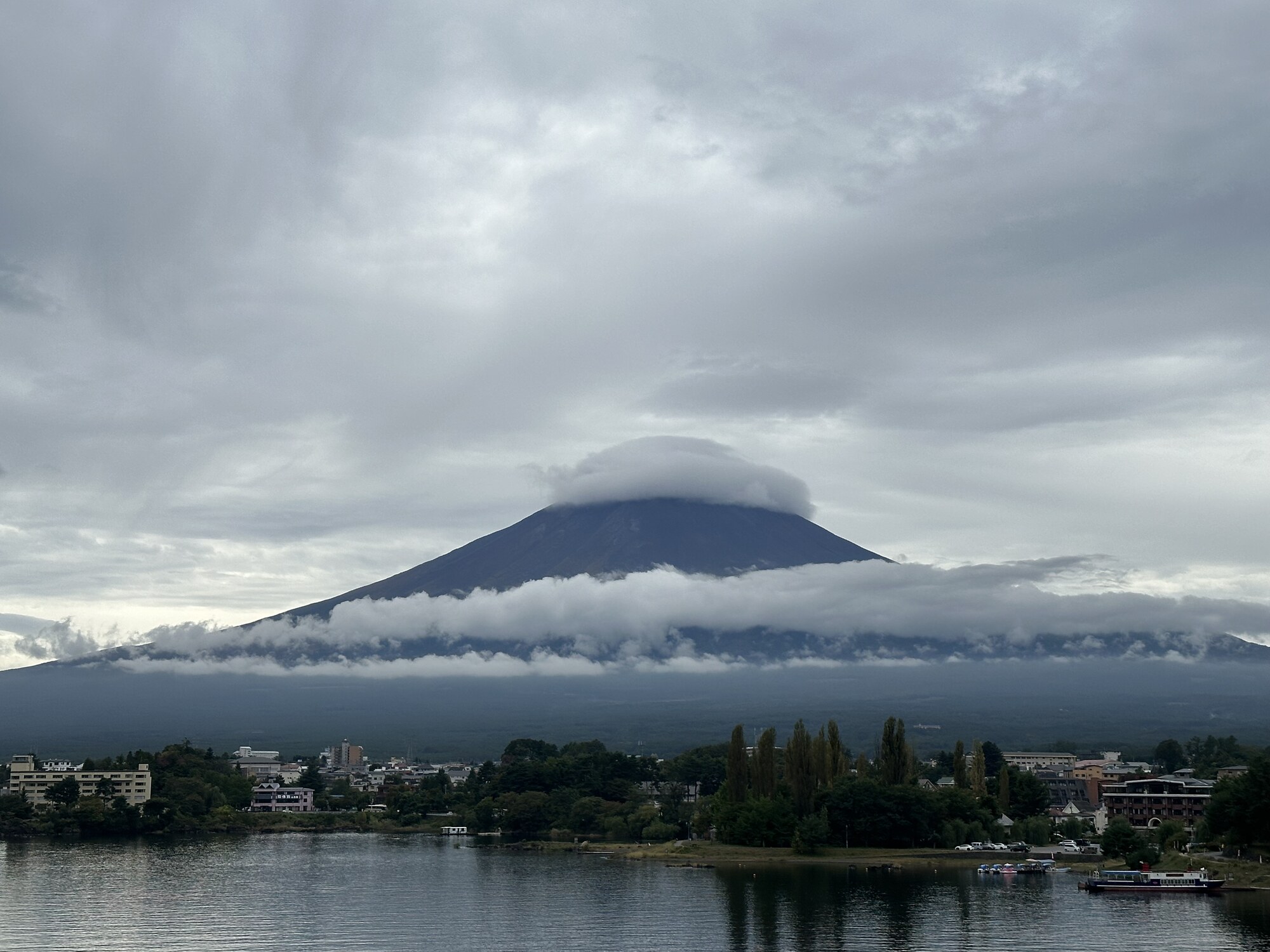A broad mountain wrapped in a horizontal band of clouds.