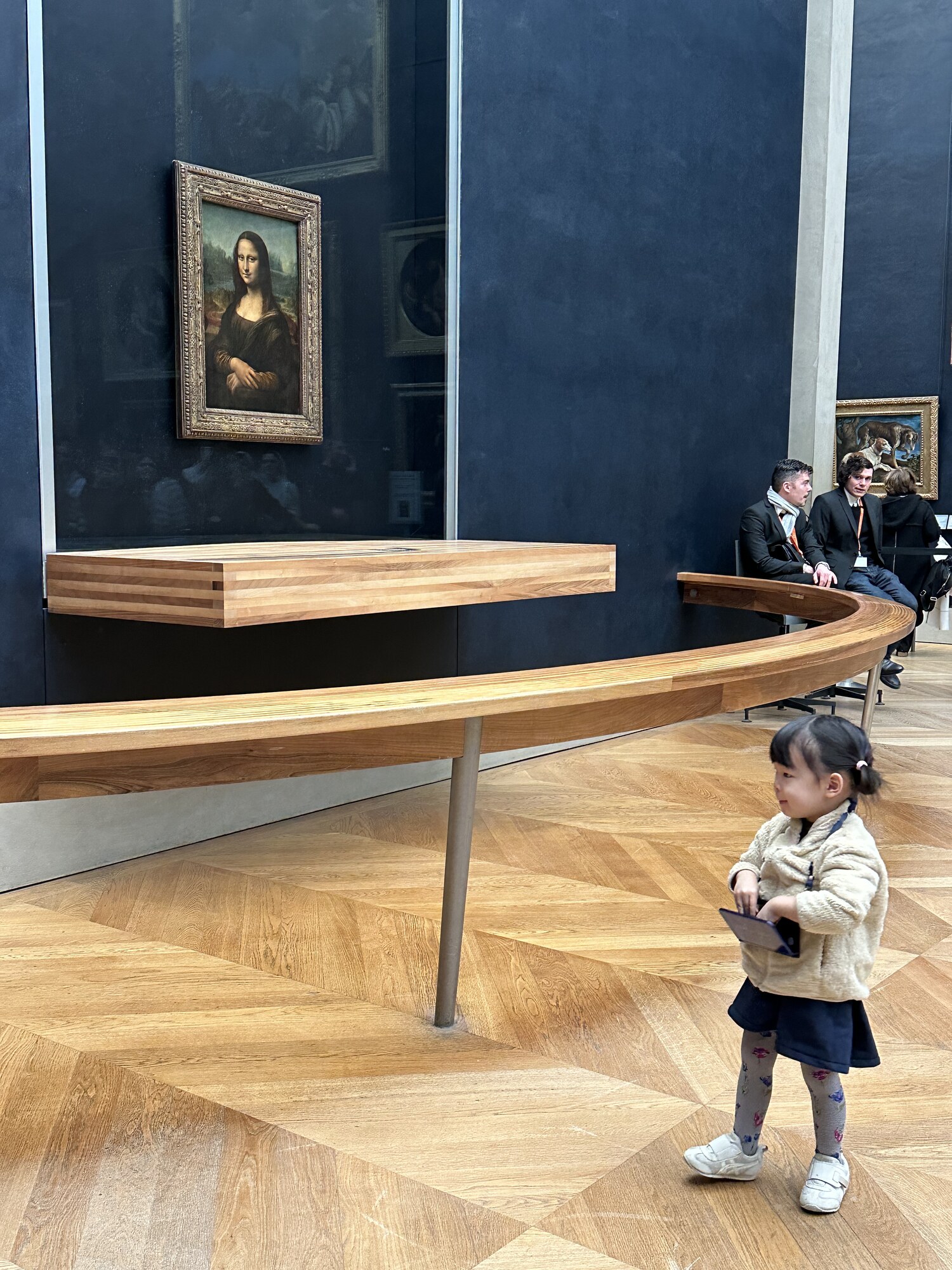A small child looking aside in a gallery near the Mona Lisa.